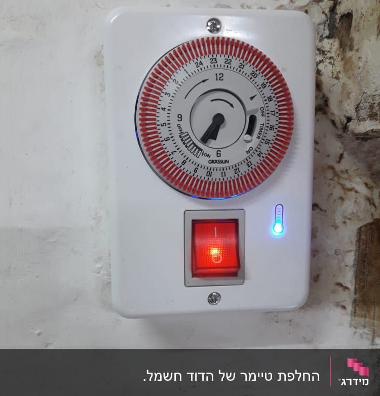 טיימר חשמלי עם מתג מואר על קיר